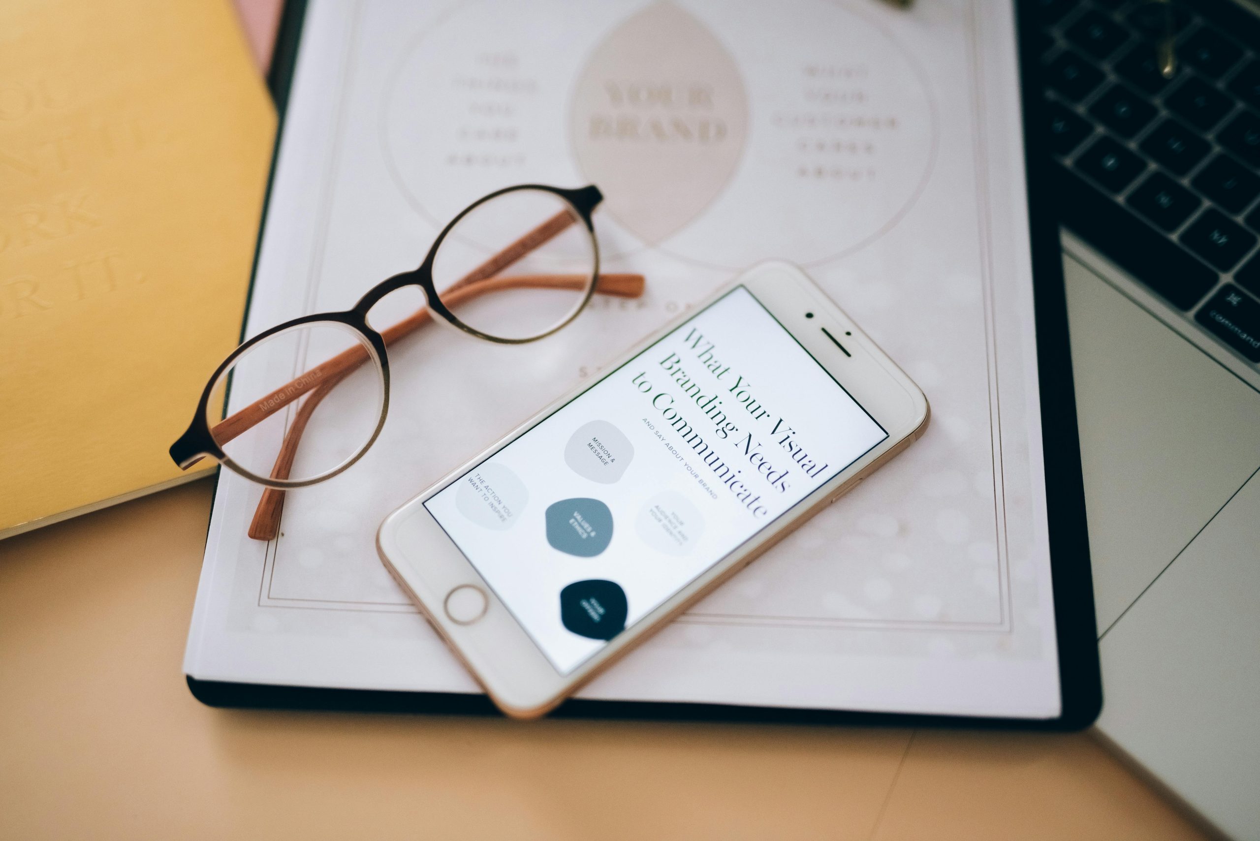 Close-up of glasses and smartphone on document about visual branding, perfect for business concepts.
