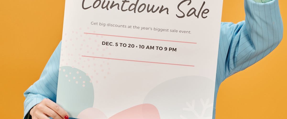 Person holding a holiday sale poster against a vibrant yellow backdrop.